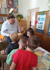 Bibliotekarz pokazuje dzieciom karty katalogowe