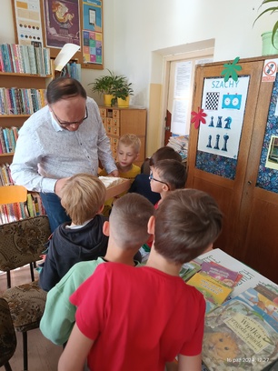 Bibliotekarz pokazuje dzieciom karty katalogowe